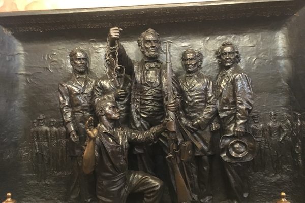 Lincoln holding a rifle, freeing the slaves