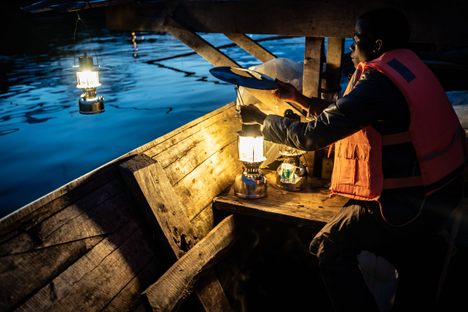 A fisherman lights lanterns on Lake Kivu in 2019.