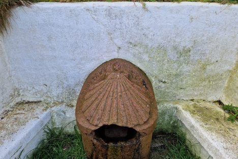 The now difficult to read inscription around the wellhead.