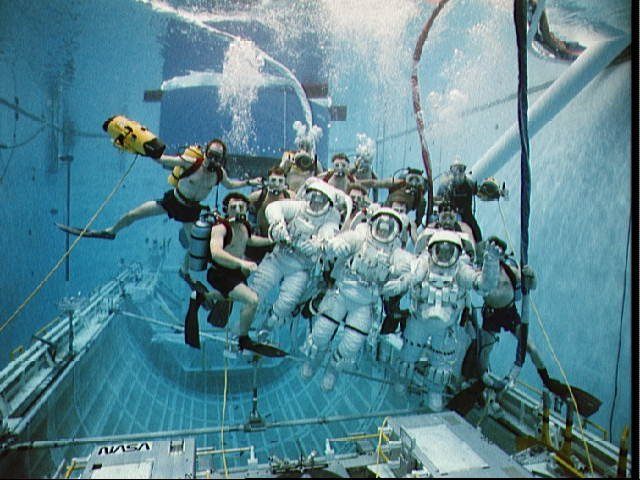 1992: In this underwater group portrait, eleven SCUBA-equipped divers pose with the three trouble shooting astronauts. Astronauts are (left to right) Clifford, Musgrave, and Voss. 
