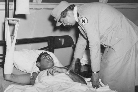 At a South Pacific hospital, Eleanor speaks with a sailor from Fort Worth, Texas, who was injured while unloading a ship. US Admiral William F. Halsey recalled being awed by the expressions on the men’s faces as the First Lady leaned over them in hospital beds.