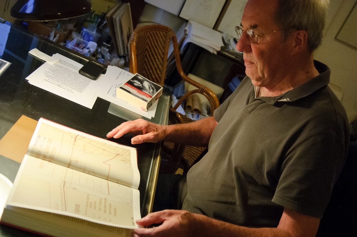 Andreas Springer looks at a book with a map of Tunnel 57.