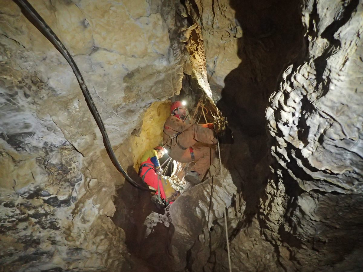 Local cavers help take down the water-diverting structure from the ceiling of Bùs del Budrio.