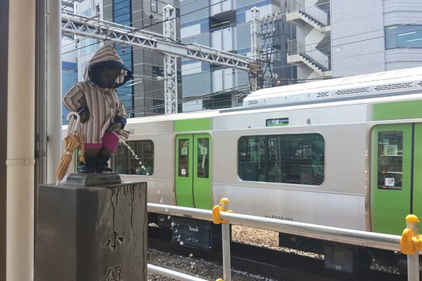 Peeing boy waits for the Yamanote line in his rainy season wear.