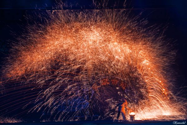 Blacksmiths cast molten iron against the city gate in lieu of fireworks