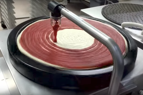 The magical Costco machine dispensing a perfect swirl of delicious pizza sauce.
