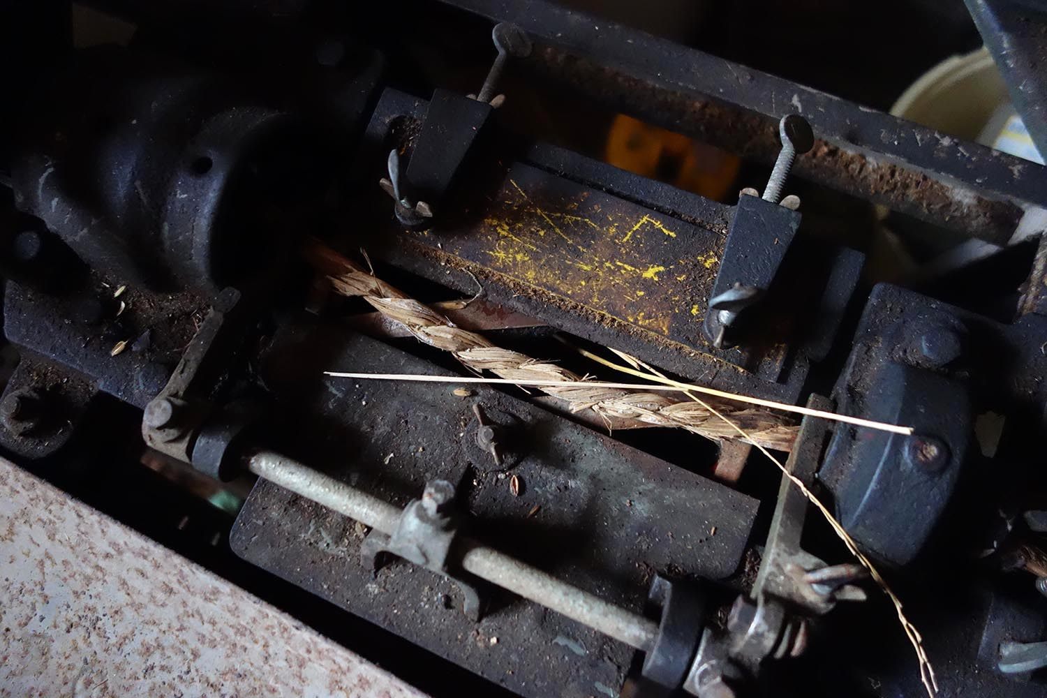 Twisting rice stalks into rope by machine (also done by hand).