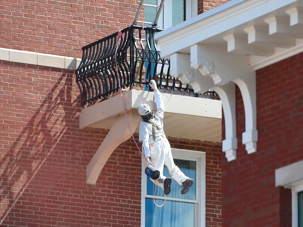 The figure of a painter, a creation of Mark Cline, hangs off a balcony of the Robert E. Lee Hotel in Lexington, Virginia, for his annual prank on Saturday, April 1, 2017.