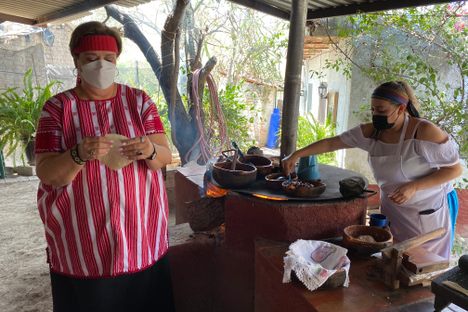 Maru Toledo and one of the "Mujeres del Maíz" make tortillas.