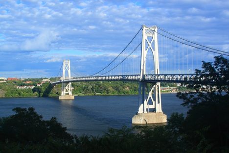 A white suspension bridge across a large river