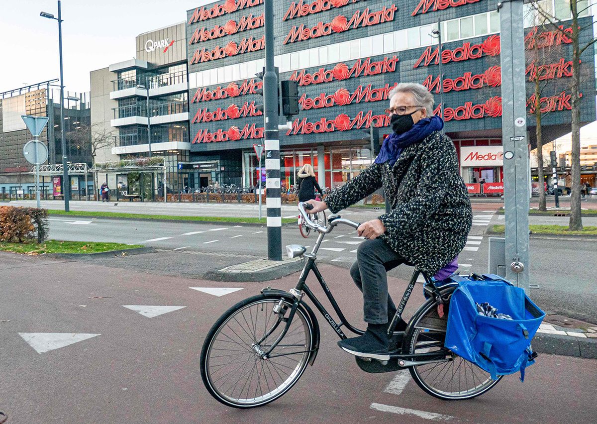 A masked woman cycles in Eindhoven's city center. Masks became mandatory in all indoor public spaces on December 1.