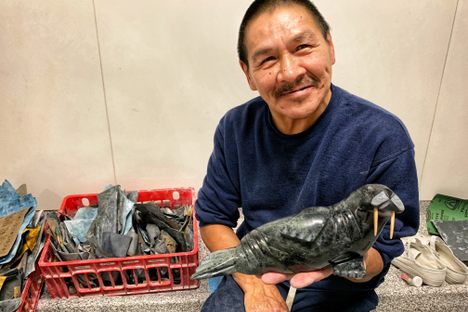 Eegeesiak Shoo holds up his carving of a walrus in Makigiarvik jail.