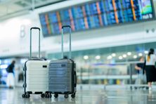 Two suitcases in an empty airport hall.