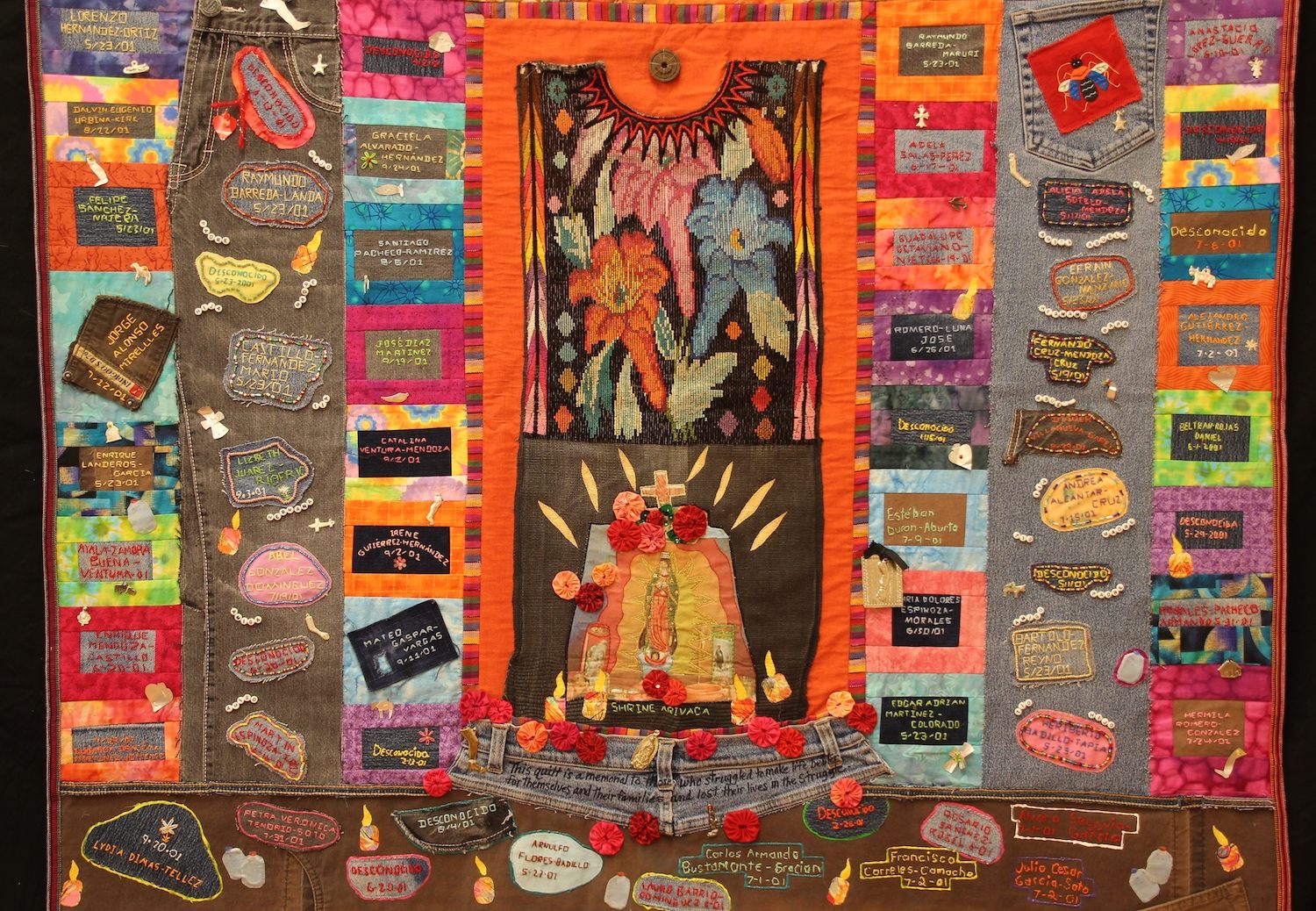 A quilt from the Migrant Quilt Project. The quilts list names of migrants who died in the Arizona desert and incorporate personal items found along migrant routes, such as jeans and handkerchiefs.