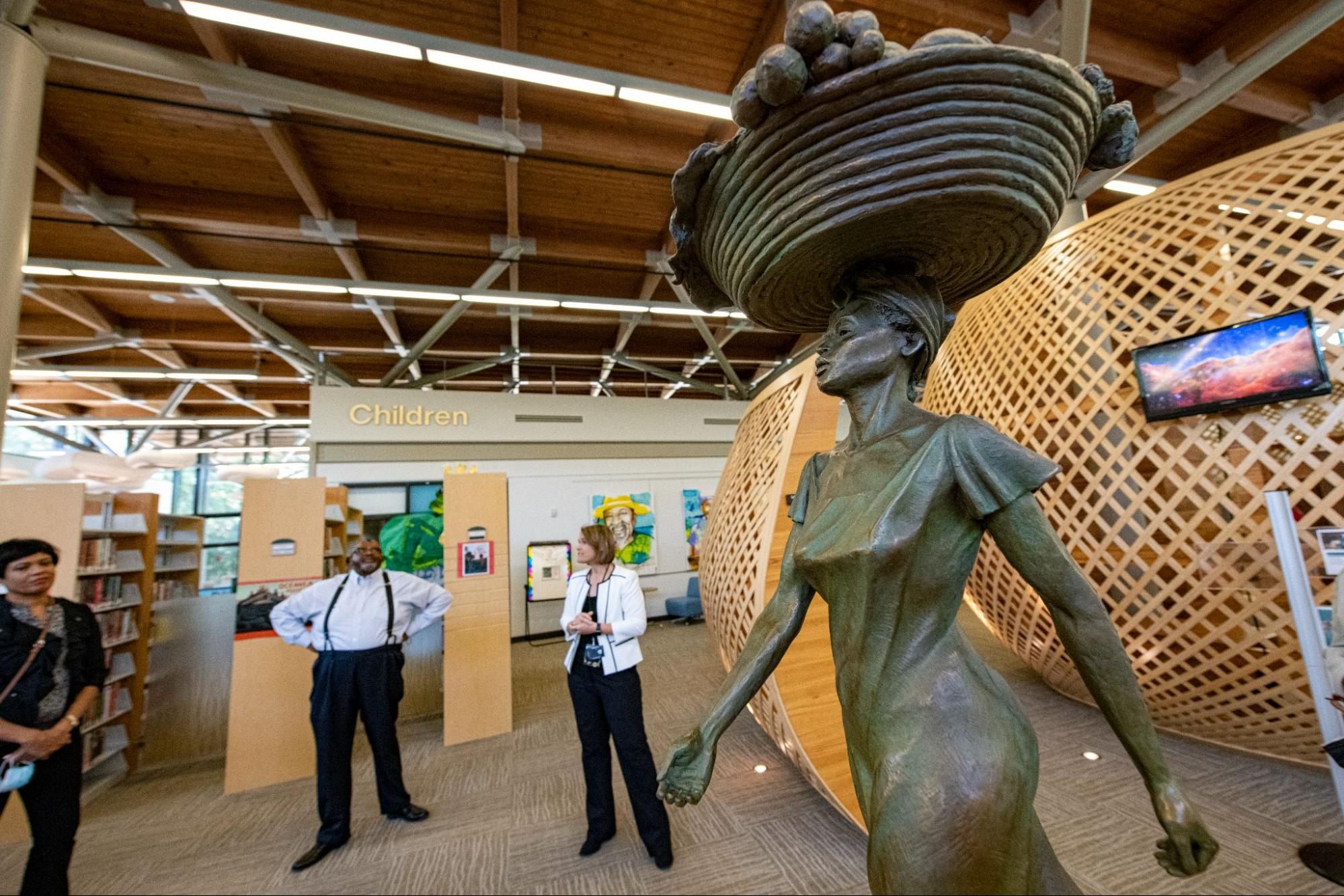 An award-winning bronze sculpture featured in the Beaufort County Library depicts a Gullah woman carrying a sweetgrass basket full of vegetables.