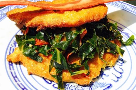 A collard sandwich, with vegan bacon on top.