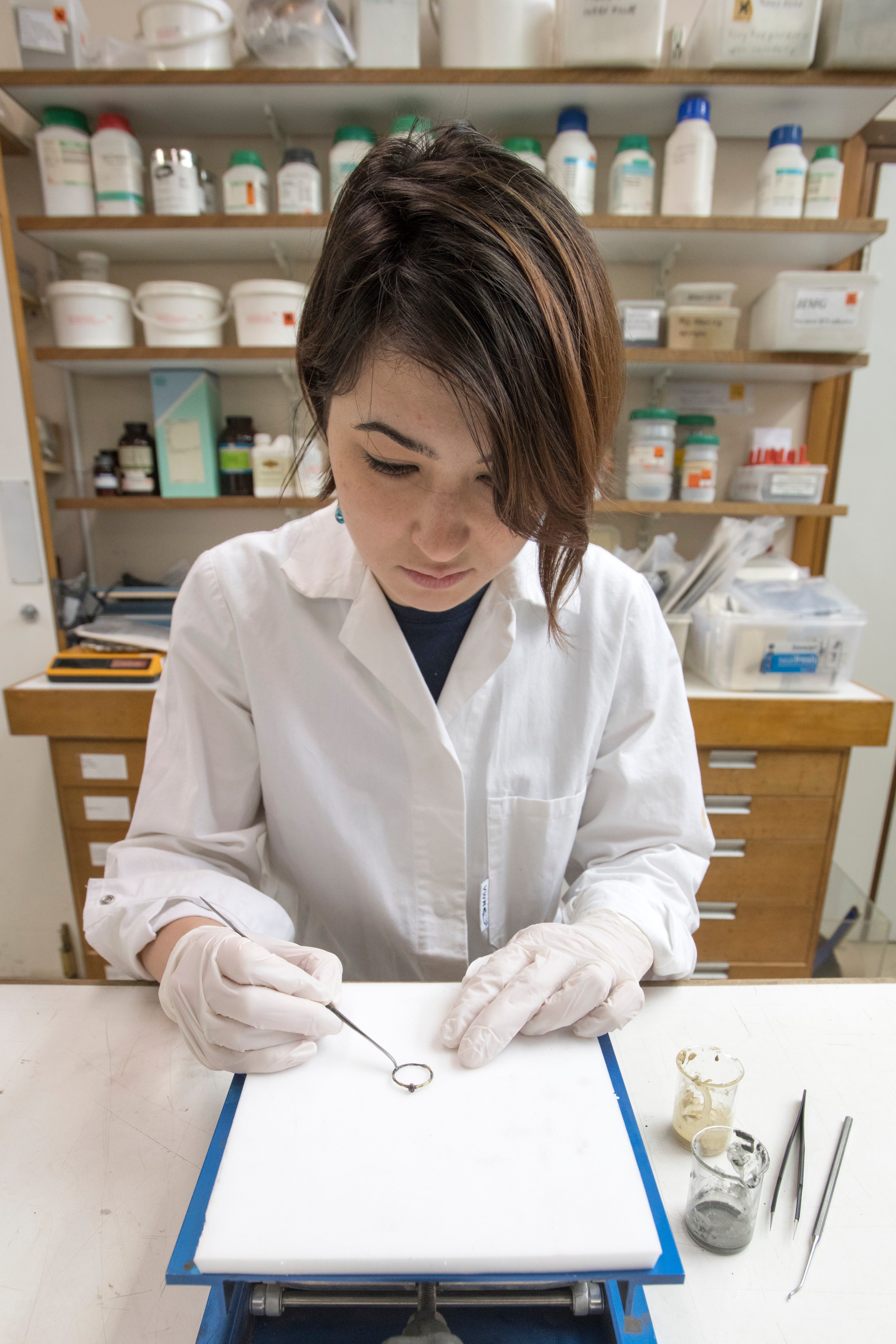 Museum of London Archaeology conservator Lucie Altenburg with the gold-plated ring found in the pit.