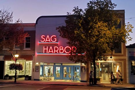 The Art Deco neon sign of the Sag Harbor Cinema at dusk.