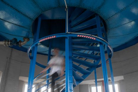 A visitor descends the spiral staircase through the reservoir.