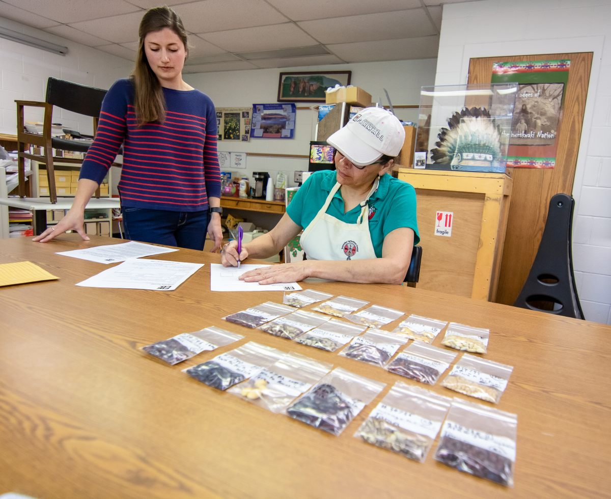 Shelley Buffalo signs the document that officially rematriates seeds from the Field Museum to the community.