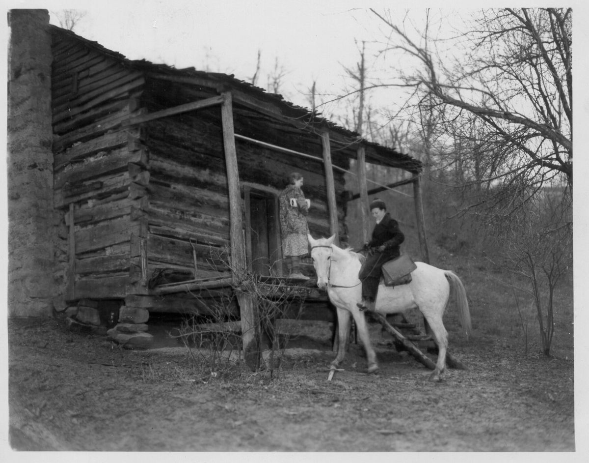 A packhorse librarian leaving a cabin after delivering books, Kentucky, c. 1930s.