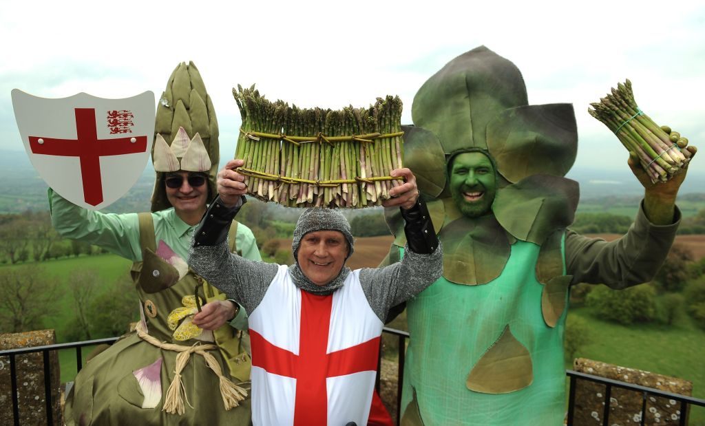 The Asparagus Fairy, St. George, and Gus the Asparagus Man pose with a "hundred" of asparagus. 