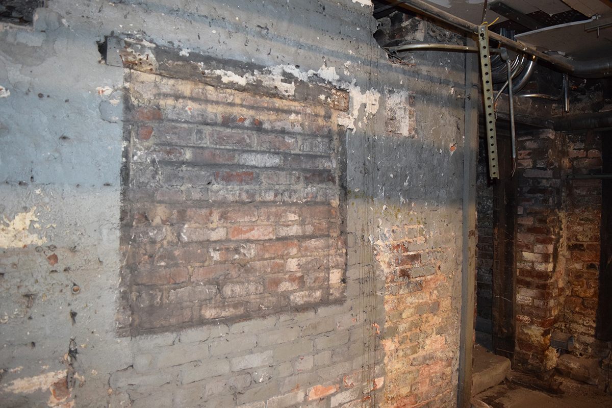 Another filled window in the Loveman Building basement with a door leading to an adjoining room. 