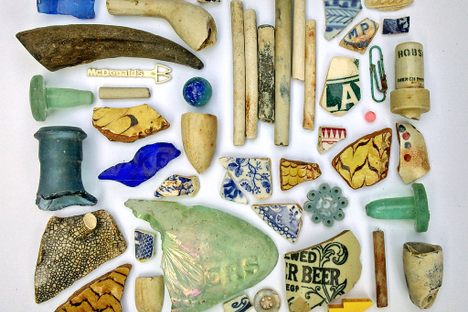 Pieces of ceramic and glass that Atherton has found in the Thames, interspersed with more recent trash.
