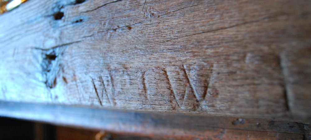 Apotropaic marks in the oak beam at the London Architectural Salvage and Supply Company's Three Pigeons restaurant.