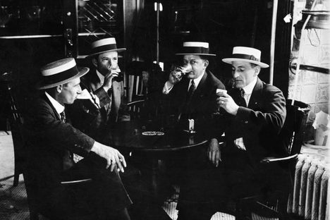 Four men in boater hats enjoy a last drink together before Prohibition begins in 1919.