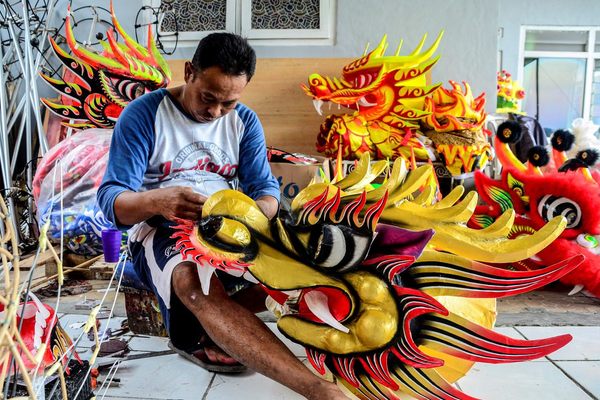 A man makes a traditional dragon heads for the Lunar New Year celebration in Bogor, Indonesia.