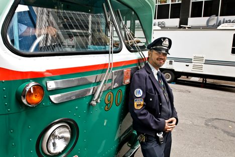 A contemporary bus driver hangs out in front of Bus 9098, a two-toned model from 1958.