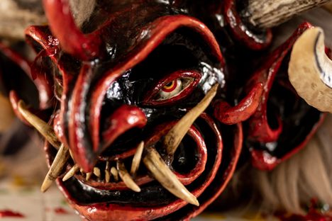 A devil mask rests on a table inside the workshop of the Minga Tunguipamba, a collective of rural performers, as dancers put the finishing touches on their masks and costumes ahead of the Diablada de Píllaro. The artists spend weeks and sometimes months creating and personalizing their masks. Many utilize horns, teeth, and furs from animals such as deer, boars, and llamas.