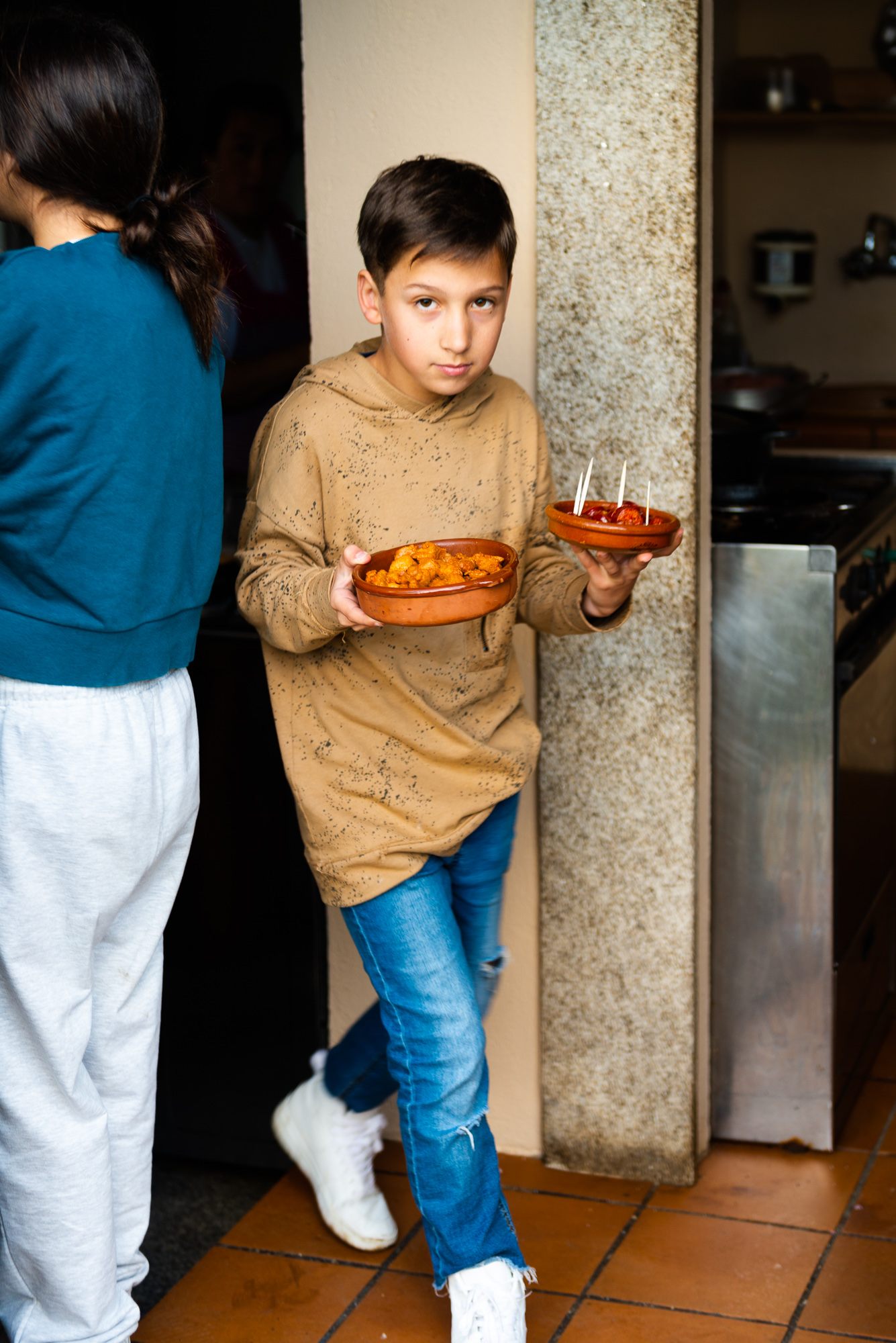 A child of the proprietors serves dishes at Furancho Berdomas.