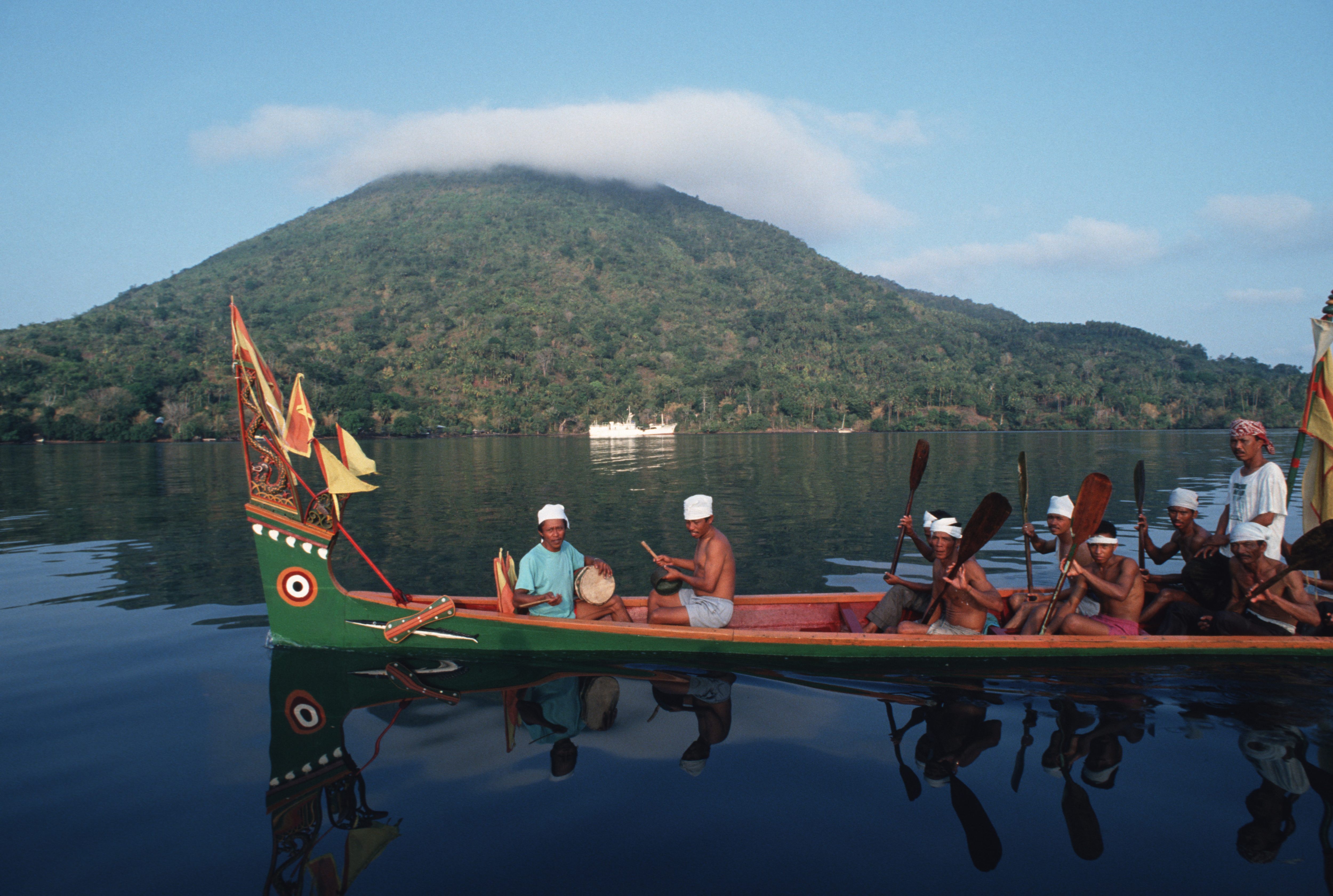Residents of Banda Naira in a traditional Kora Kora war canoe greet a visiting ship.