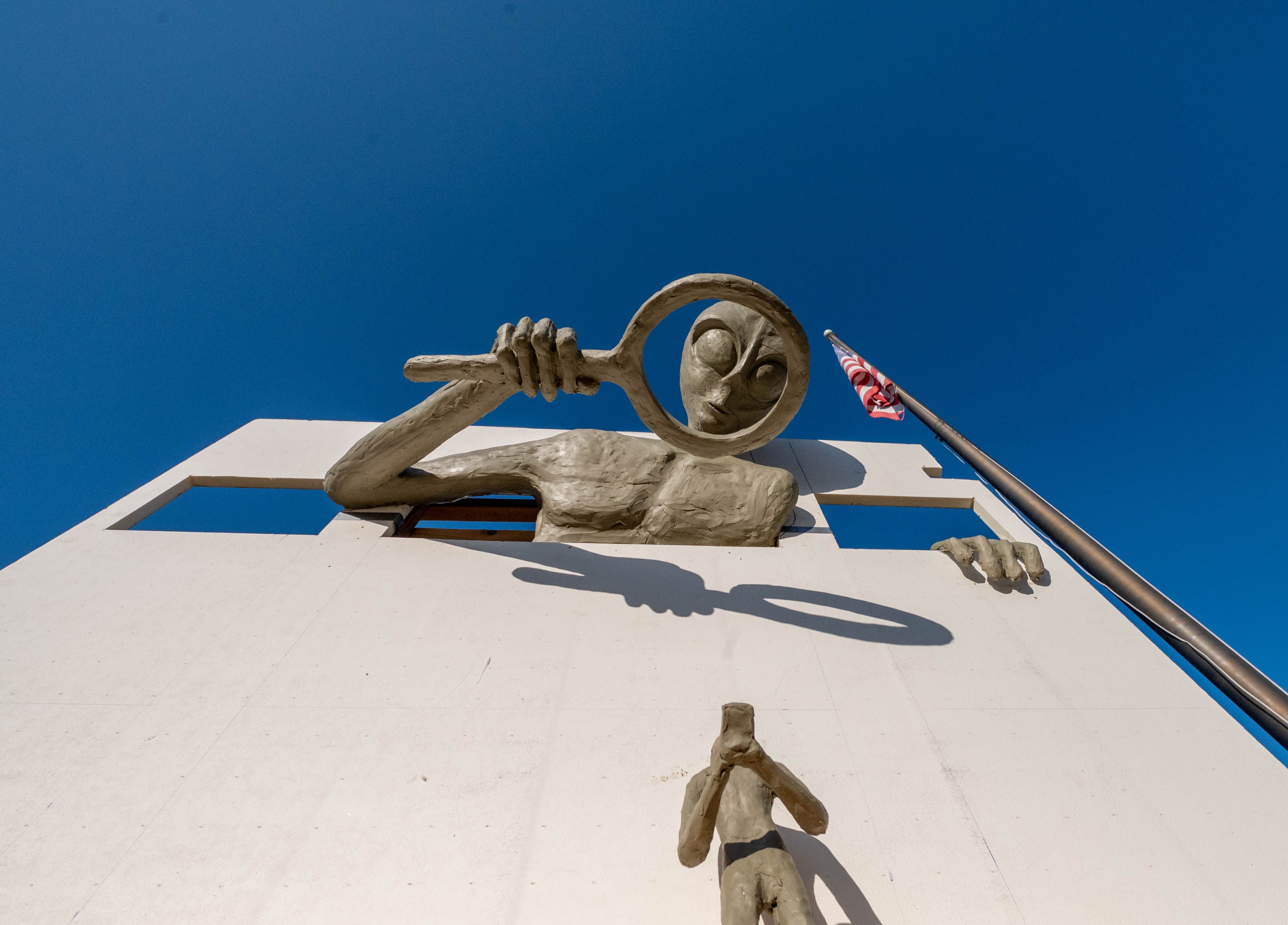 Clive the Alien examines Earthlings below with his magnifying glass. 