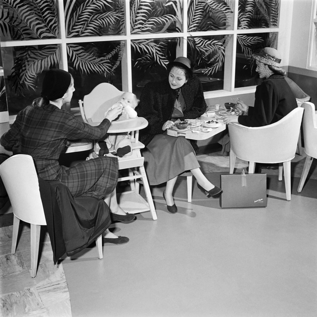 Three women and one baby enjoy lunch at the Lord and Taylor tea room.