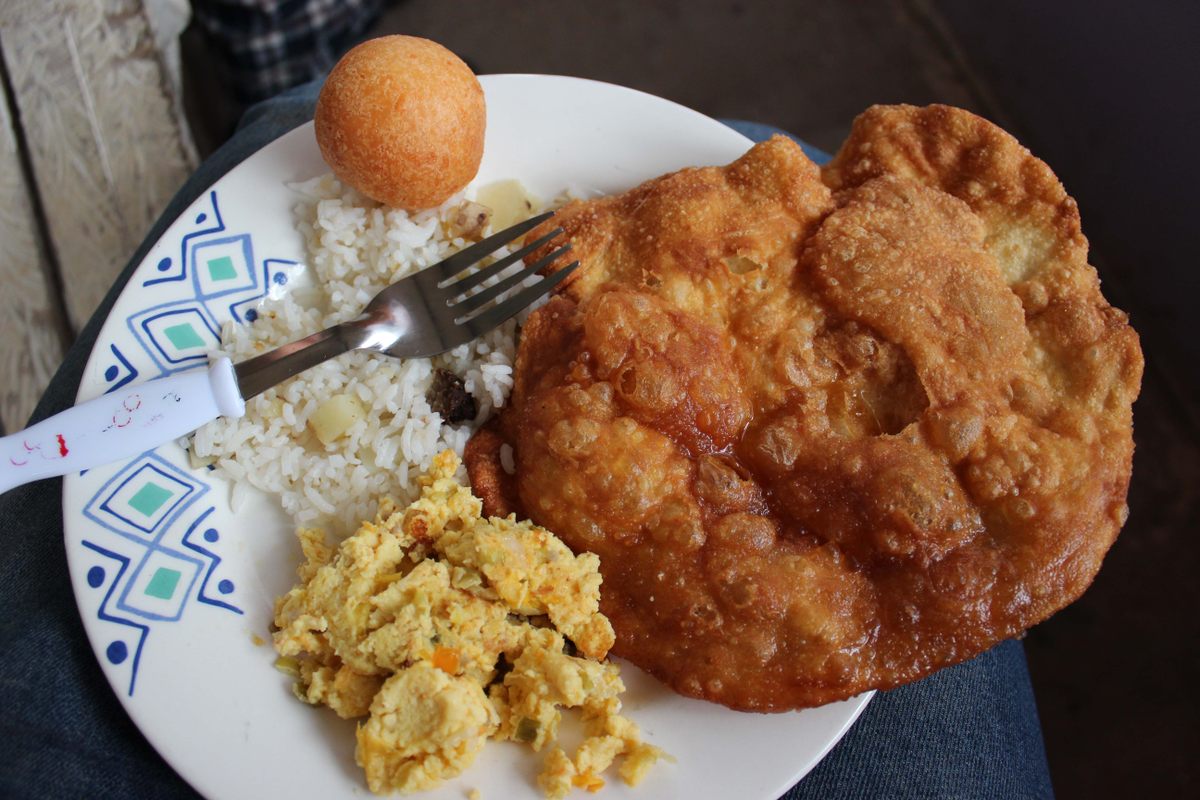 Cancharina with rice, scrambled eggs, and a buñuelo (Colombian cheese fritter).