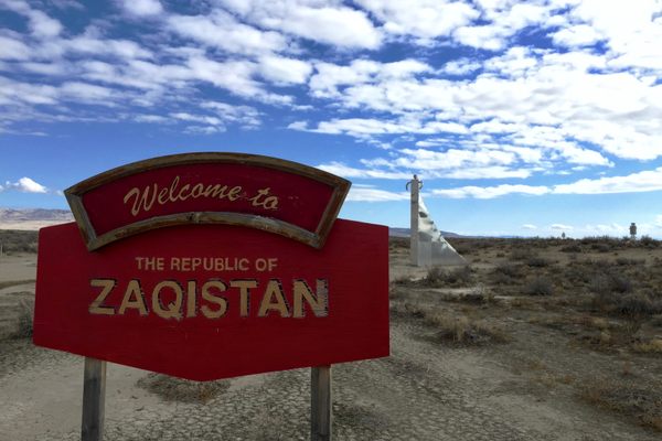 Zaqistan welcome sign, with the Decennial Monument in the background.