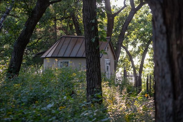 A small church set in the woods behind a tree
