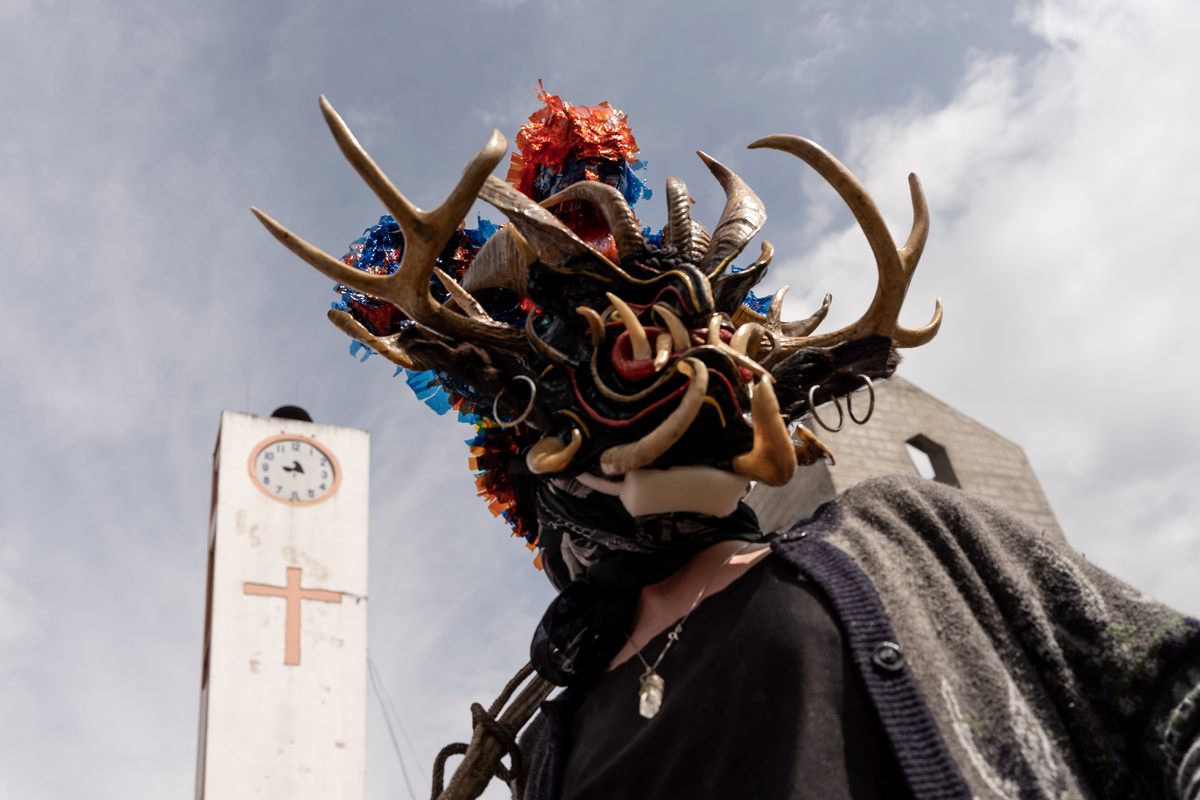 A devil passes by the local church along the procession route in Píllaro. Over time, the Diablada has become an expression of rebellion against the authority of Spanish colonizers and the Catholic Church.