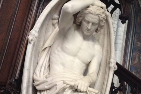 The sculpture is titled "Le génie du mal"