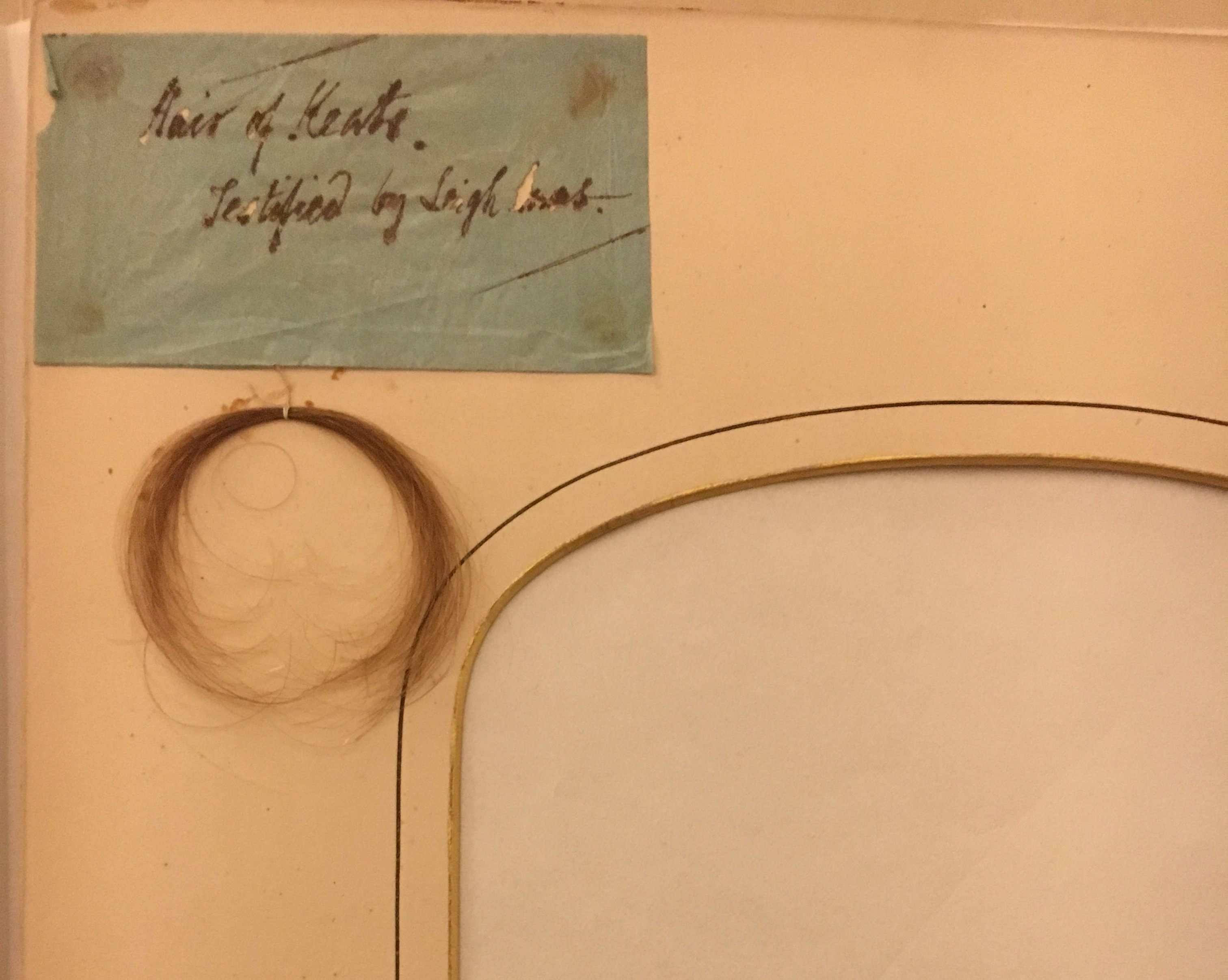 John Keats's hair, with a note from Leigh Hunt attesting to its provenance. The empty frame probably originally contained a portrait of the poet. 