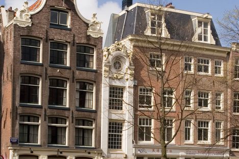Row of old houses with the narrow Kleine Trippenhuis or "Little Trip House" on Kloveniersburgwal canal.