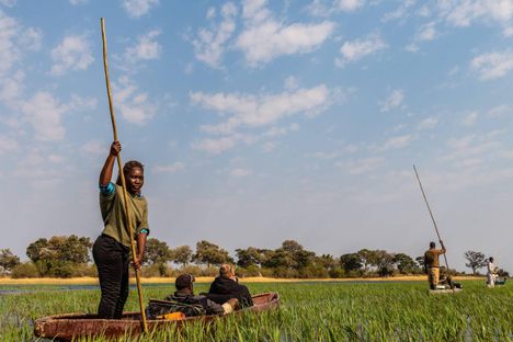 Okavango Delta, Botswana - August 2, 2022. Western Tourists travelling in a mokoro, along the delta. This type of travel is traditional among the locals of the delta.