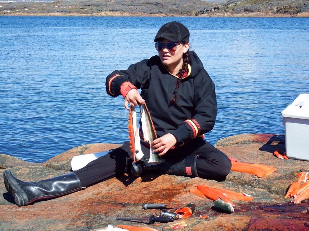 Qaunirq Chapman learns to filet Arctic char, which will become <em>pittik,</em>or sun-dried fish.