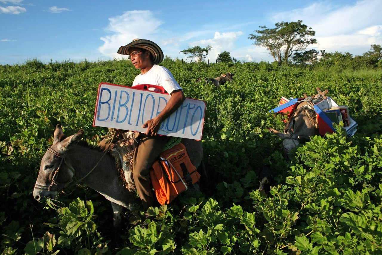 Burros Alfa and Beto, seen here with Luis Soriano in 2008, have been helping the teacher deliver books for more than 20 years.