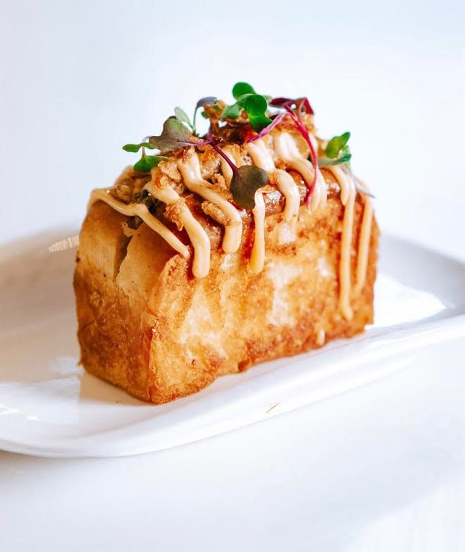 Chef Manuel Loreto's "<em> Berza </em> hot dog" adalah putaran modern pada klasik gitano.” width=”auto” data-kind=”article-image” id=”article-image-105451″ loading=”lazy”/><figcaption class=