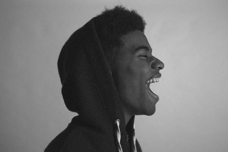 A young man bursting out into laughter. 