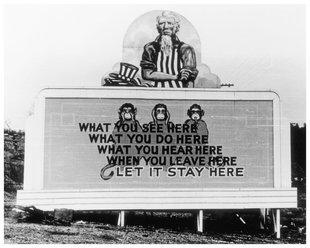 Billboards like this one, photographed in 1943, reminded workers to keep their work confidential.